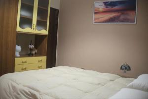 瓦尔博若纳Appartamento OUT OF TIME的卧室配有白色的床和梳妆台。