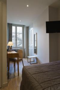 里昂剧场酒店的酒店客房配有一张床和一张带台灯的书桌