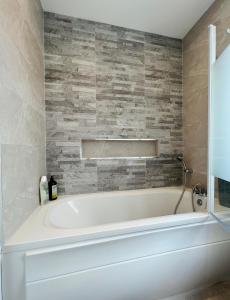 拉托特Gems in Ratoath的浴室配有白色浴缸及石墙