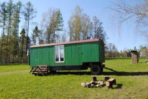 Šťastná Maringotka的绿色拖车坐在草地上