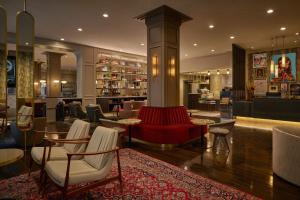 达拉斯Renaissance Saint Elm Dallas Downtown Hotel的大堂设有酒吧,配有红色的沙发和椅子