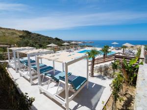 阿齐亚佩拉加Spiros-Soula Thematic Suites的享有带椅子和遮阳伞的海滩美景