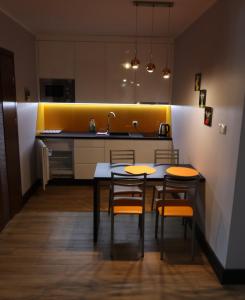 德布吉Karla, apartamenty i pokoje w Dębkach的厨房配有桌椅和水槽。