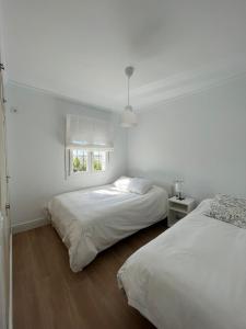 查兹拉德拉谢拉Villa Mariaje的白色客房的两张床,设有窗户