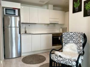 拉赫蒂Kotimaailma Apartments Lahti的厨房配有冰箱和椅子
