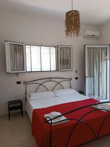 切萨雷奥港La Luna的一间卧室配有一张带红色毯子的大床