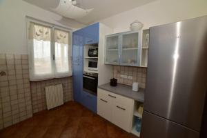 费拉约港Casa vacanze il Pastore Tedesco的厨房配有蓝白色橱柜和冰箱。