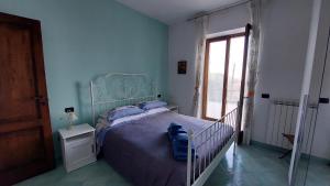 伊斯基亚La Casetta nel Bosco的一间卧室配有一张带蓝色床头板的床和窗户