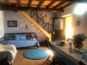 西尔维拉Casal dos Carpinteiros - Carpenters Couple的客厅配有蓝色的床和一张桌子