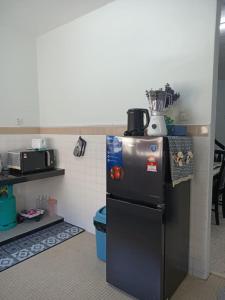 克提RIANI HOMESTAY的一间厨房,里面配有黑色冰箱