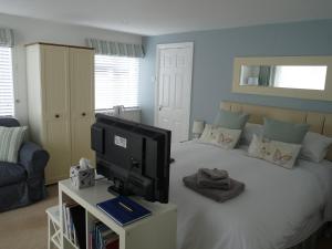 波马利斯格德福住宿加早餐旅馆的一间卧室配有一张床、电视和沙发
