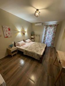 奥林匹亚基·阿克蒂Villa Rafailia的一间卧室设有一张大床,铺有木地板
