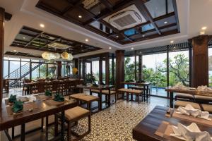 Pu LuongEBINO PULUONG RESORT的餐厅设有桌椅和大窗户。