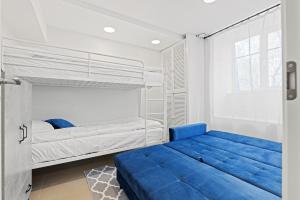 塔林Sirena Apartment - Self check-in and free parking的一间卧室配有两张床和蓝色的沙发