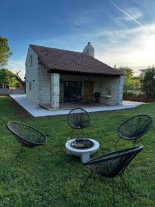 布罗托尼贾Villa Ondina的草丛中带两把椅子和火坑的房子