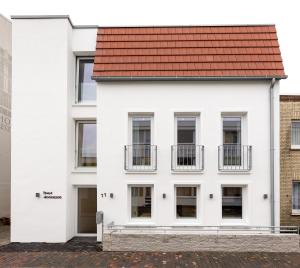诺德奈Haus Andersen Apartment ZWEI的白色的建筑,有红色的屋顶