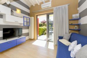 西尔米奥奈Acquarius Resort Sirmione - MGH的客厅配有蓝色的沙发和电视