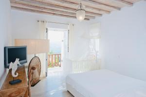 米克诺斯城Dreamy Boho 5bed Villa with Pool and Ocean View的一间白色卧室,配有床和电视