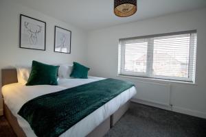 比林汉姆Skipton Lodge的一间卧室配有一张带绿色床单的床和一扇窗户。