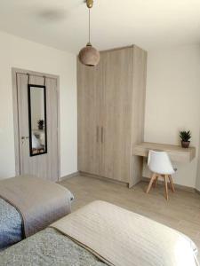 利加里亚Chatzidakis Apartment/Inspiration harmony的一间卧室配有一张床、一个橱柜和一张桌子