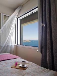 利加里亚Chatzidakis Apartment/Inspiration harmony的一张带盘子的带杯子和窗户的床
