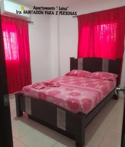 科韦尼亚斯Apartamento JHON的红色窗帘的房间的一张床位