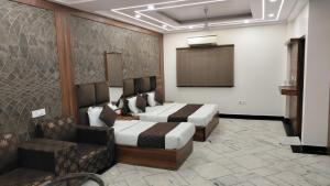 新德里HOTEL SINGH CONTINETAL的酒店客房,设有两张床和一张沙发