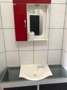 伊塔帕里卡Pousada Ponta de Areia的浴室水槽设有红色橱柜和镜子