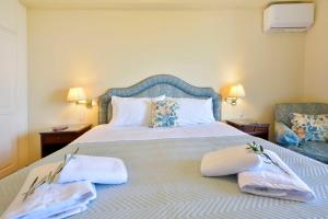 AnemómylosCorfu Ionian Blue的一间卧室配有一张大床和毛巾