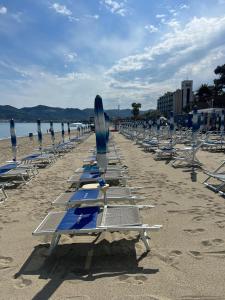 萨沃纳Casa di Riccardo的海滩上一排沙滩椅和遮阳伞