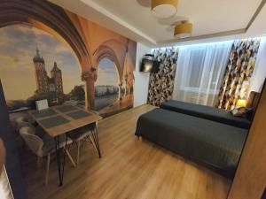 克拉科夫Komfortowo i cicho - Apartament的一间卧室配有一张床、一张桌子和一幅画
