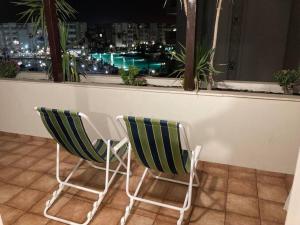 莫纳斯提尔2 Bedrooms apartment swimming pool的窗前两把绿色和白色椅子