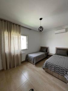 莫纳斯提尔2 Bedrooms apartment swimming pool的一间卧室设有两张床和窗户。