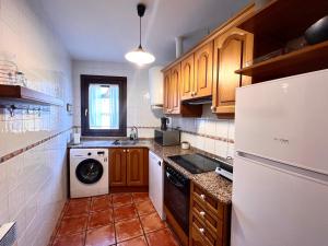 阿尔特伦Apartament d'Àssua - L'Amfitriona的厨房配有白色冰箱和洗碗机。