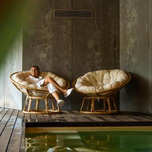 加亚新城Quinta do Pedregal Hotel & Spa的坐在游泳池旁两把椅子上的人