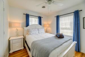 翡翠岛Beachfront Emerald Isle Vacation Rental with Deck!的卧室配有白色的床和蓝色窗帘