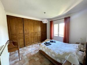 布克贝莱尔Villa Terres Blanches à 10 min d'Aix-en-Provence的一间卧室配有一张床、一张书桌和一个窗户。