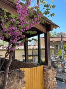 Saint Antonin du VarLe relais de Romane Logement 3 étoiles tout confort, piscine的木栅栏旁一棵紫色花树