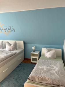 格赖夫斯瓦尔德Ferienhaus Feldblick的一间卧室设有两张床和蓝色的墙壁