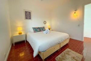 法鲁Ria Beach House的一间卧室配有一张床和两盏灯,墙上有标志