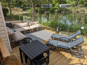雷日卡普费雷charmant Mobil-home climatisé - Cap ferret的庭院设有蓝色长椅、沙发和桌子
