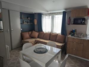 雷日卡普费雷charmant Mobil-home climatisé - Cap ferret的客厅配有沙发和桌椅
