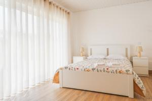 蓬德利马Casa Vilar R/C的白色卧室配有床和白色窗帘