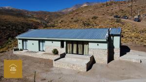 洛斯莫莱斯Piri Home Casa de Montaña的山坡上一座蓝色屋顶的小房子