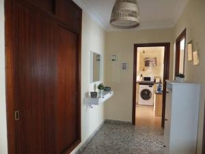 克莉丝蒂娜岛Magnífico piso céntrico的走廊设有门,厨房设有洗衣机和烘干机