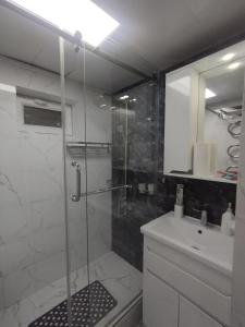 杜尚别Small house in a centr的一间带玻璃淋浴和水槽的浴室