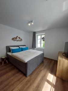 贝希特斯加登AlpenLodge Berchtesgaden的一间卧室配有一张带蓝色枕头的大床
