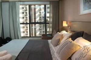 巴西利亚Flat Premium Particular Cullinan Hotel的酒店客房设有一张床和一个大窗户