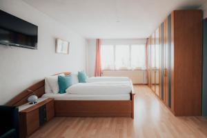 Gais盖斯克隆酒店的一间卧室配有带白色床单和蓝色枕头的床。