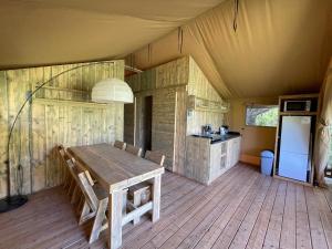 SeptfondsLodges du Bois Dodo - ancien Camping de Bois Redon的帐篷内的用餐室配有木桌
